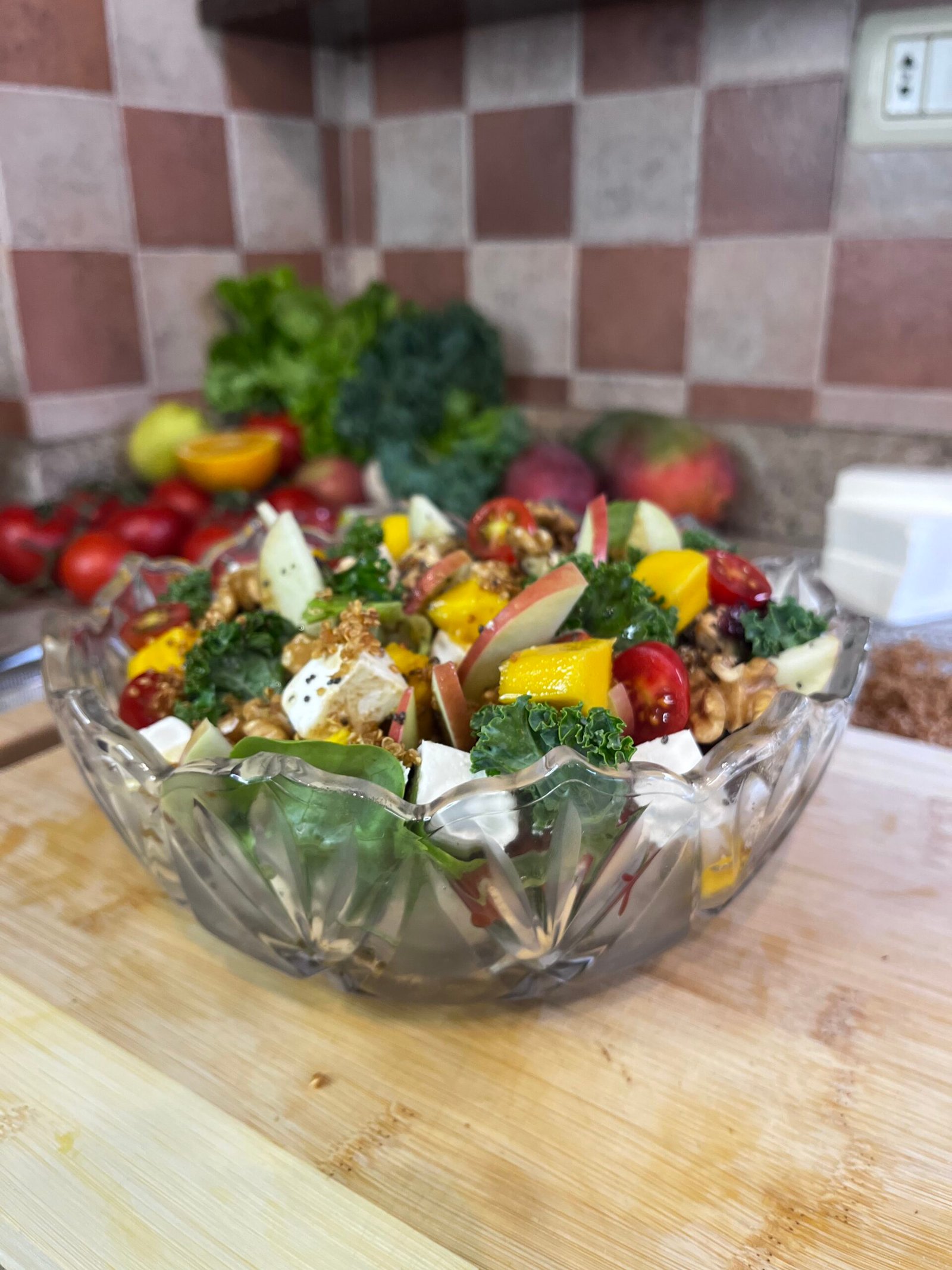 a bowl of colorful salad sitting on a wooden board