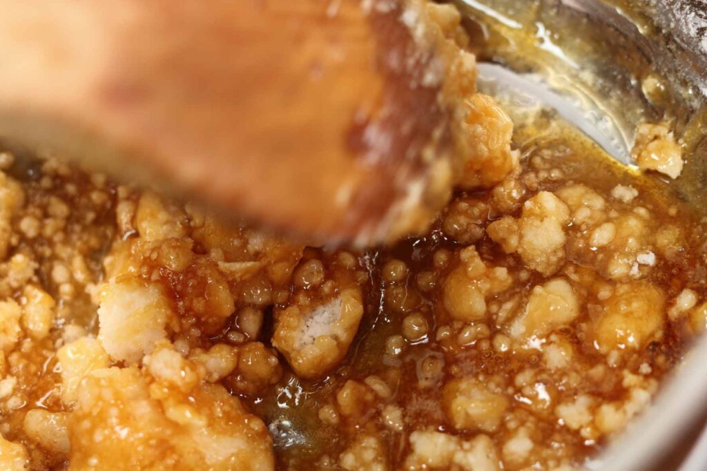 Sugar crystallizing during homemade caramel sauce preparation after stirring the boiling sugar