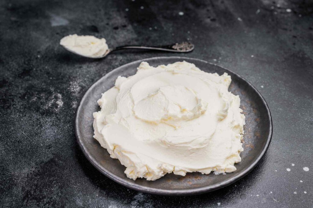 Creamy mascarpone cheese on a plate, the essential ingredient for an authentic Italian tiramisu recipe.