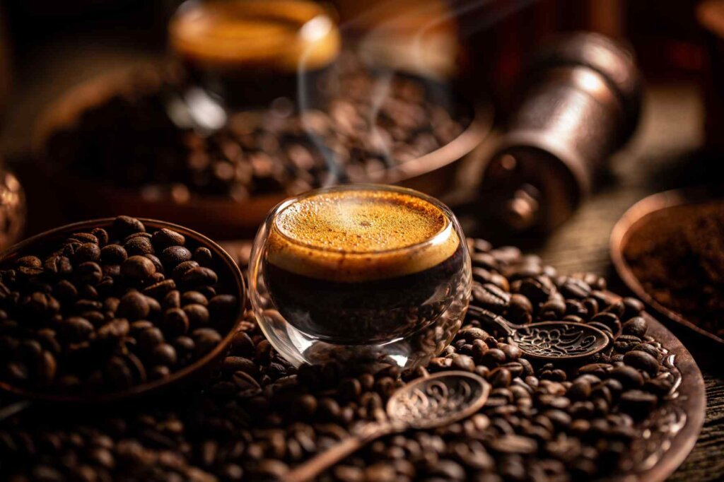 Freshly brewed espresso surrounded by roasted coffee beans, used to soak Savoiardi for authentic Italian tiramisu.