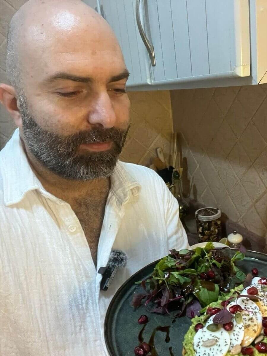 chef holding a plate of avocado egg bruschetta