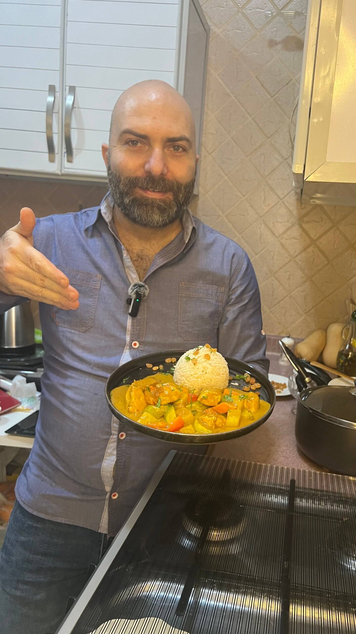 Chef François holding a plate of creamy chicken curry with vegetables in a rich sauce