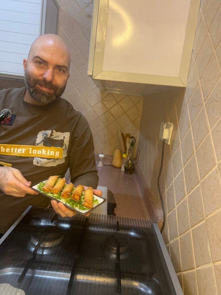 chef holding a plate of Lebanese cheese rolls
