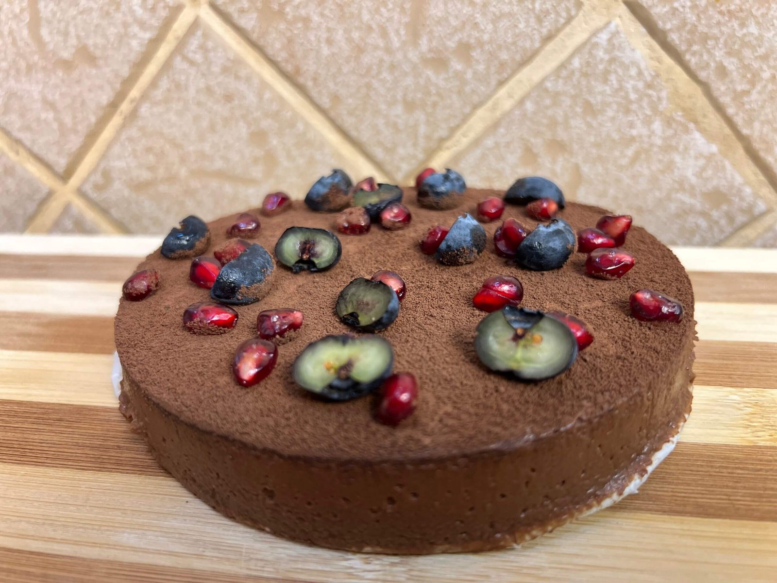 Smooth chocolate mousse cake made with apples and dark chocolate, topped with blueberries and pomegranate seeds