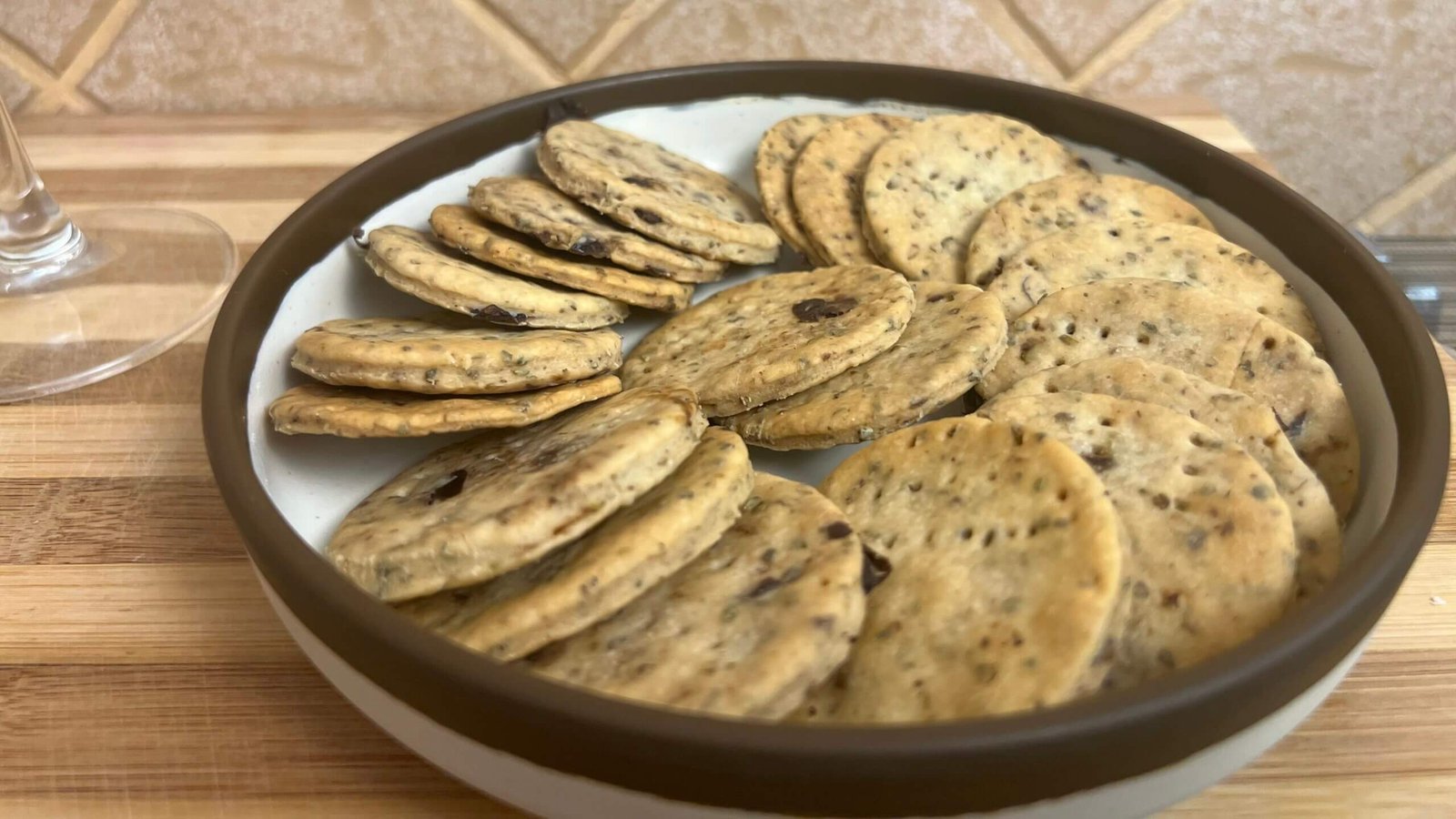 Plate of crispy thyme and olives breadsticks shaped like round crackers on a serving dish