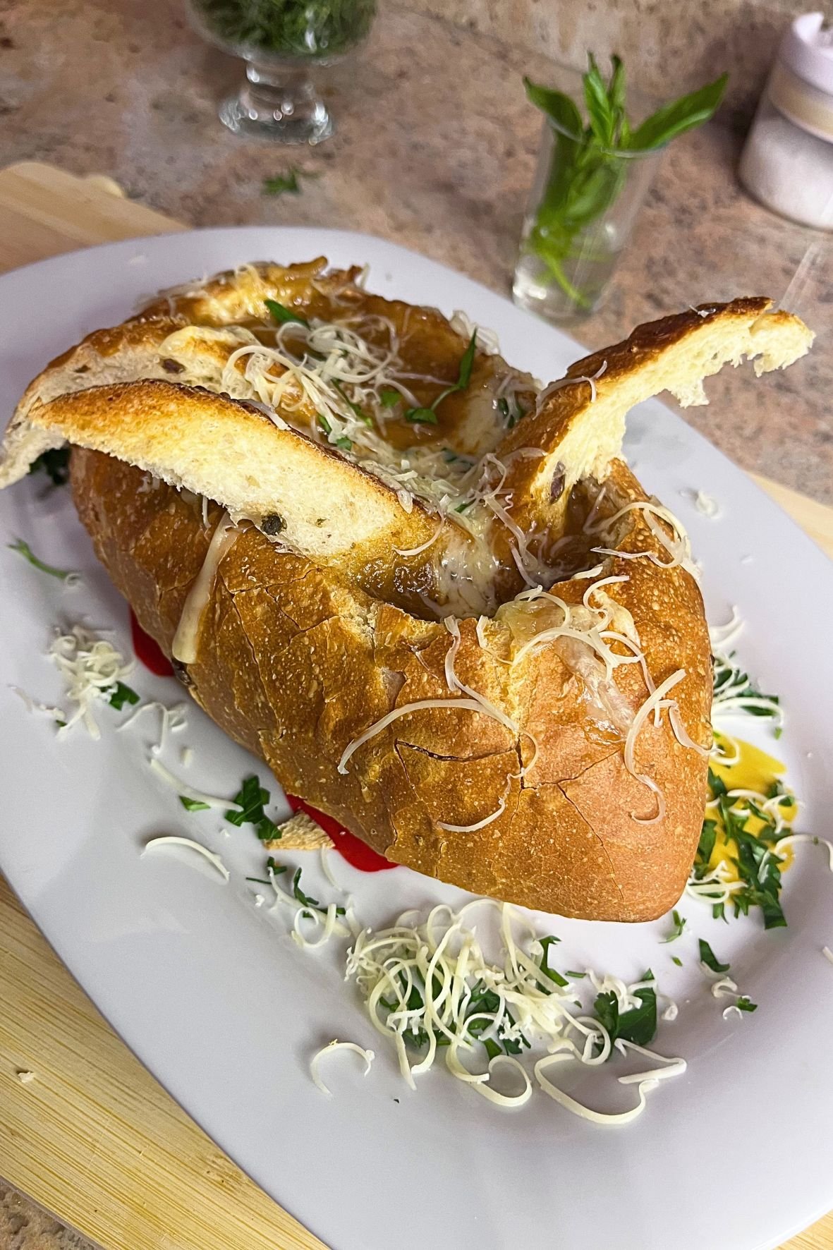 French onion soup served in a crusty bread bowl, topped with melted cheese and toasted bread slices