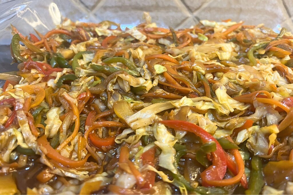 Colorful stir-fried vegetables with cabbage, carrots, and bell peppers used as spring roll filling