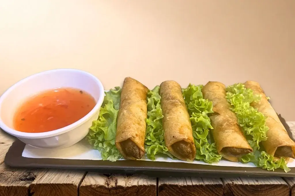 Golden crunchy spring rolls served on fresh lettuce with sweet and sour dipping sauce