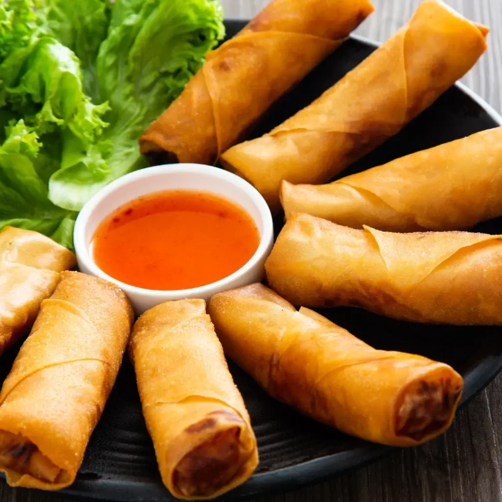 Crispy golden spring rolls served with sweet chili dipping sauce and fresh lettuce
