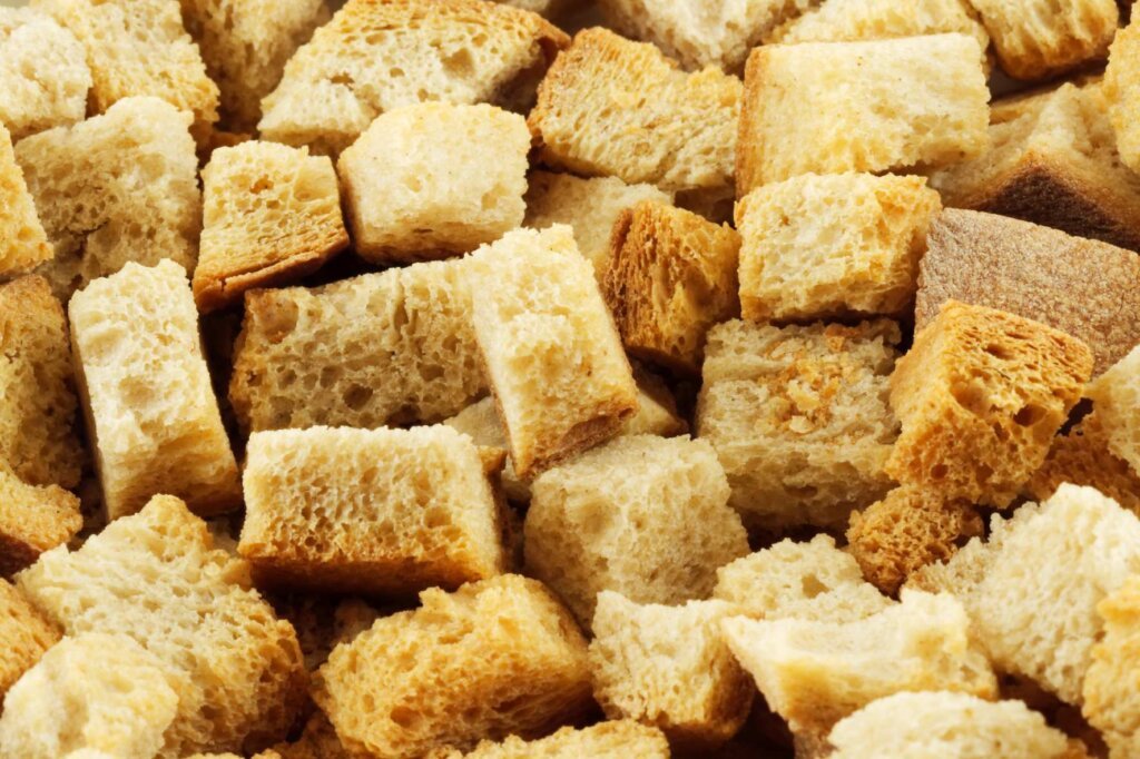 Close-up of crispy homemade croutons made from toasted bread cubes with a golden-brown crust.