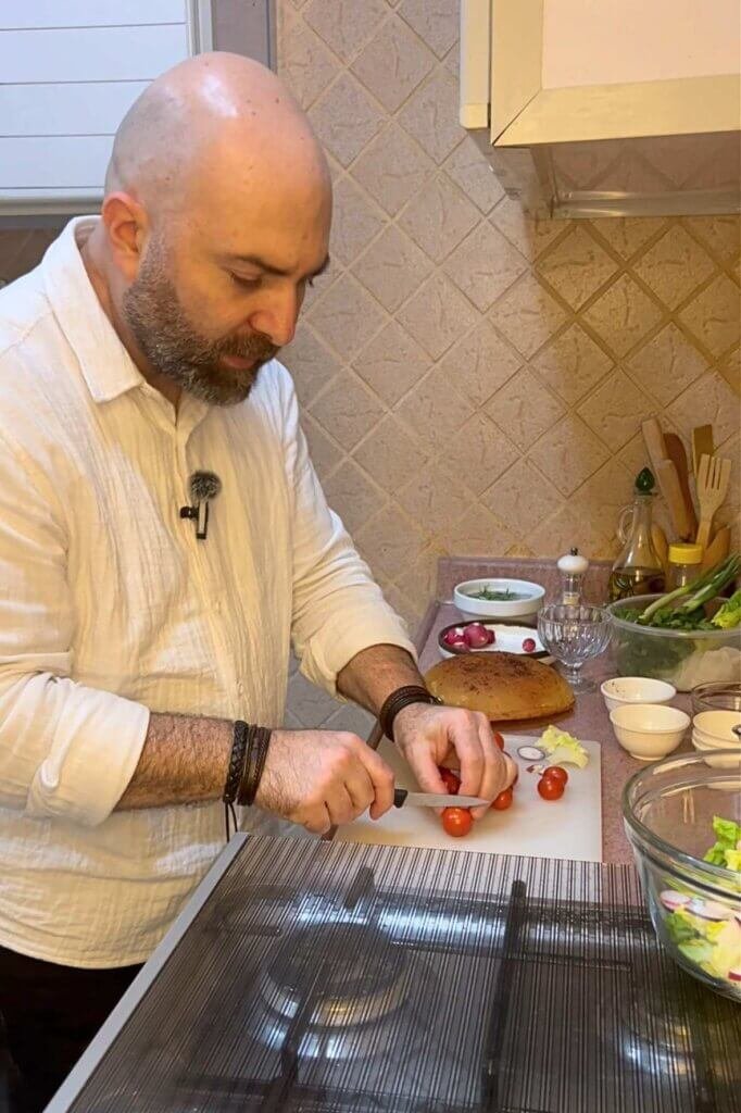 Chef François preparing fresh vegetables for authentic Lebanese fattoush salad in a home kitchen.