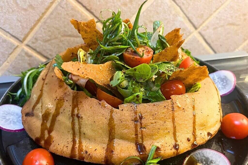 Authentic Lebanese fattoush salad served inside crispy baked Arabic bread with fresh vegetables and herbs.