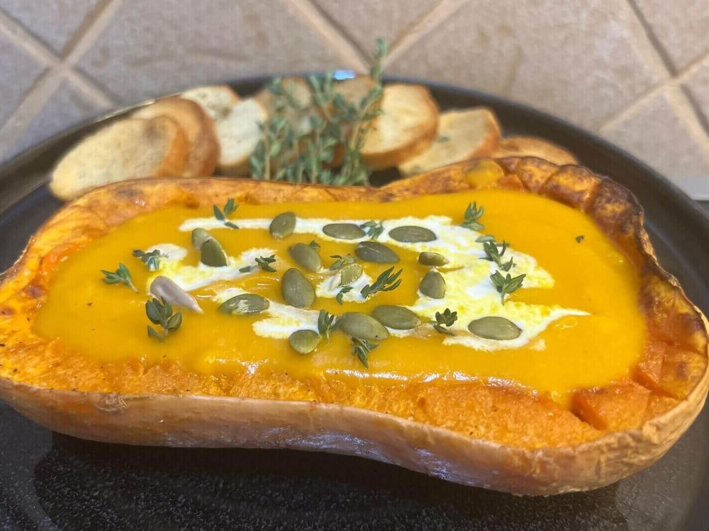 easy pumpkin soup recipe, the pumpkin is in a plate with the soup inside the pumpkin