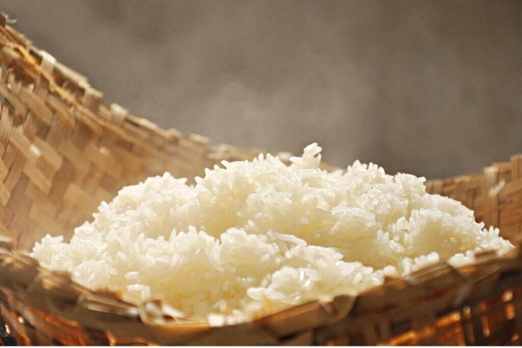 Close-up of freshly cooked sticky white rice in a woven basket