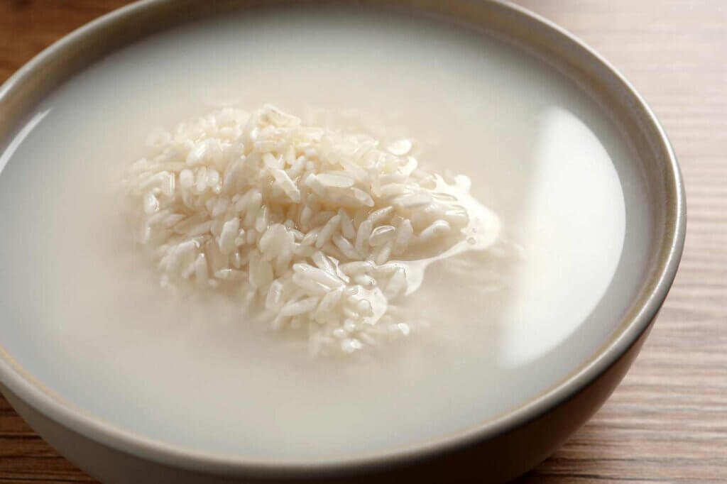 White rice soaking in cloudy starchy water in a bowl