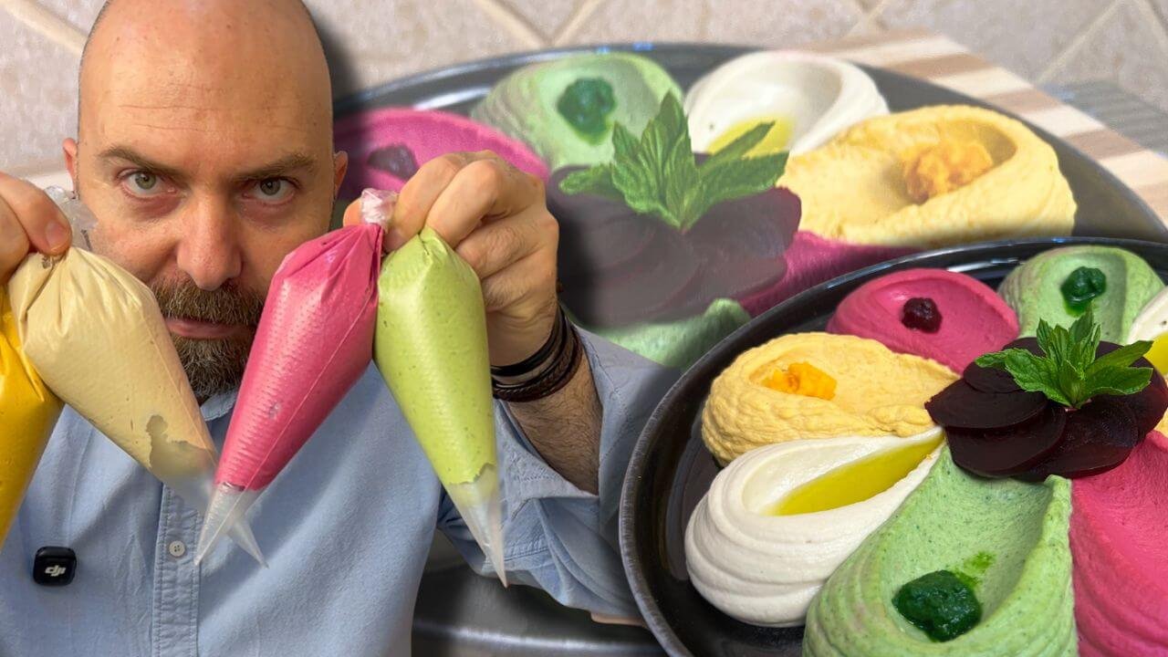 Chef François holding colorful hummus piping bags beside a platter of pink, green, white, and yellow hummus decorated with beetroot, mint, and olive oil.