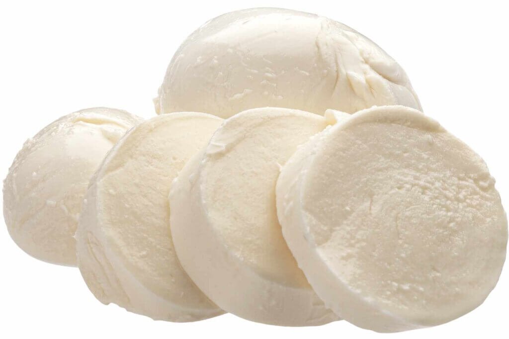 Fresh mozzarella cheese balls sliced in half, showing their soft, creamy interior on a white background.