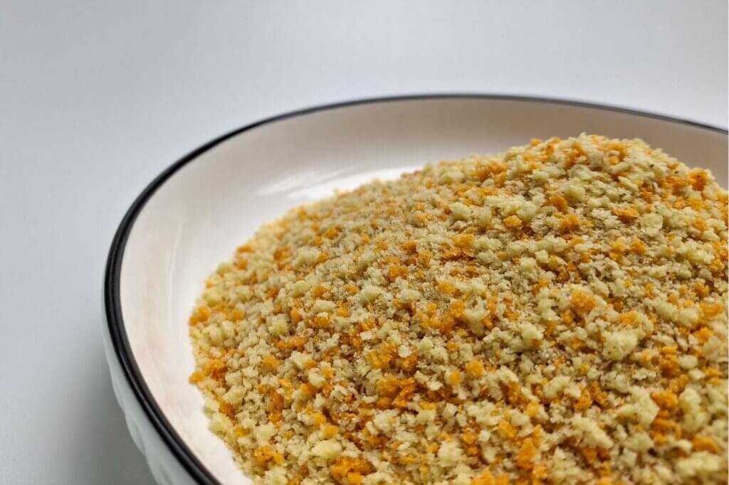 Bowl of Italian-style breadcrumbs blended with herbs, seasonings, and Parmesan cheese, ready to be used for coating chicken, fish, or vegetables.