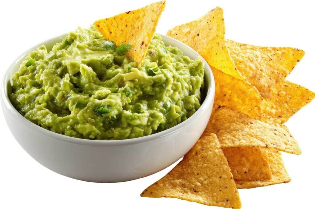 Bowl of fresh guacamole served with crispy tortilla chips, showcasing the creamy texture and vibrant green color of the avocado dip.