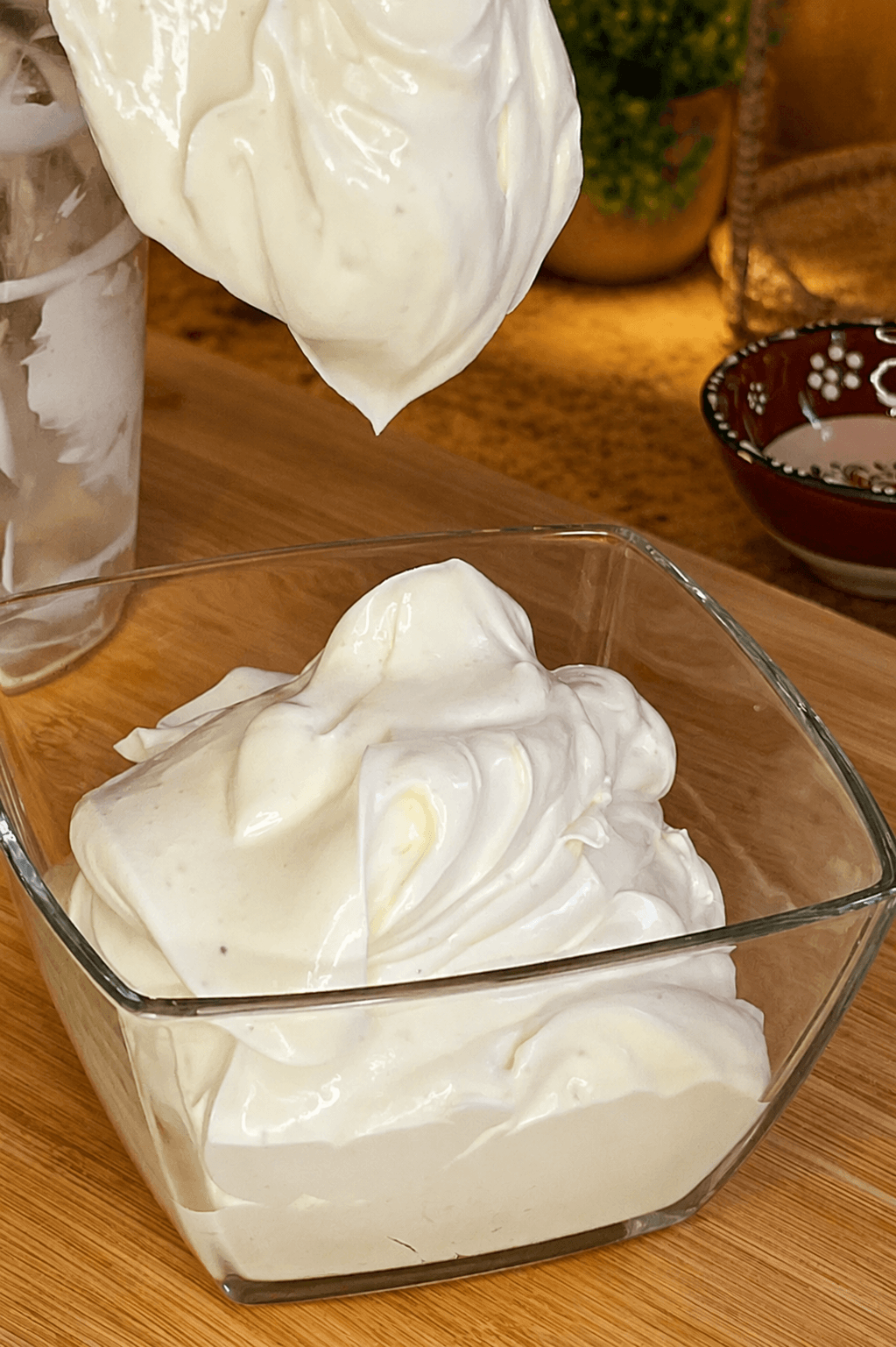 Creamy homemade mayonnaise with a smooth, thick texture in a glass bowl
