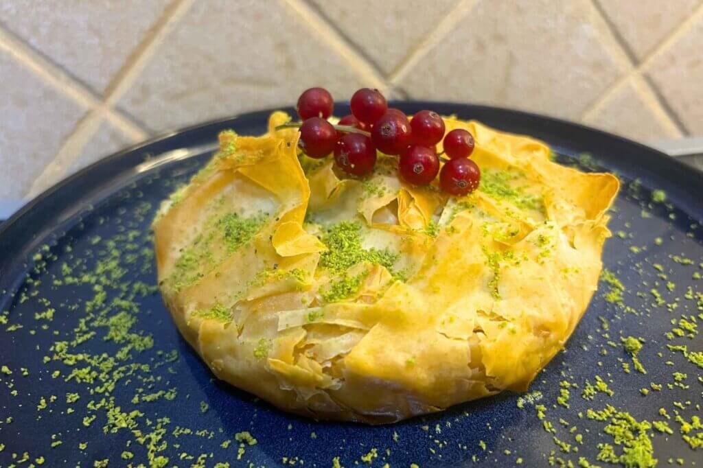 Freshly baked Baklava Cheese Pie made with crispy golden phyllo dough and a rich cheese filling, served with a sprinkle of pistachios.