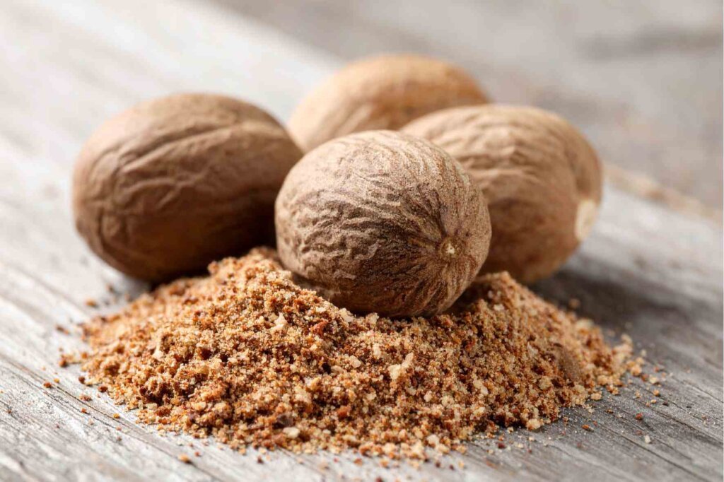 Whole and ground nutmeg used to season creamy mashed potato purée.