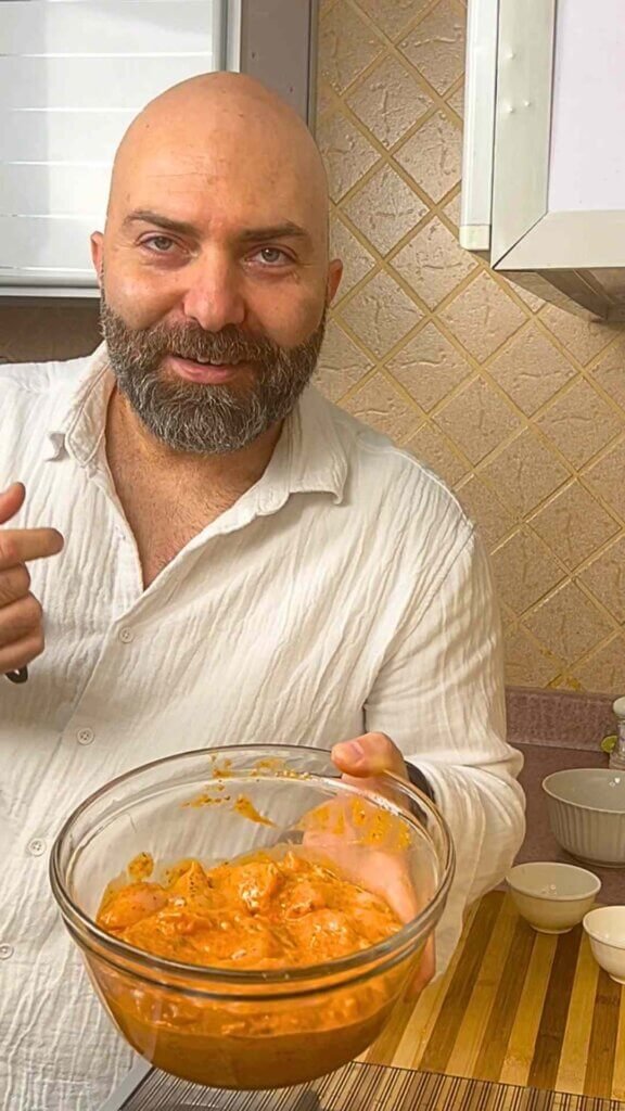 Chef François holding a bowl of homemade chicken tawook marinade before marinating the chicken