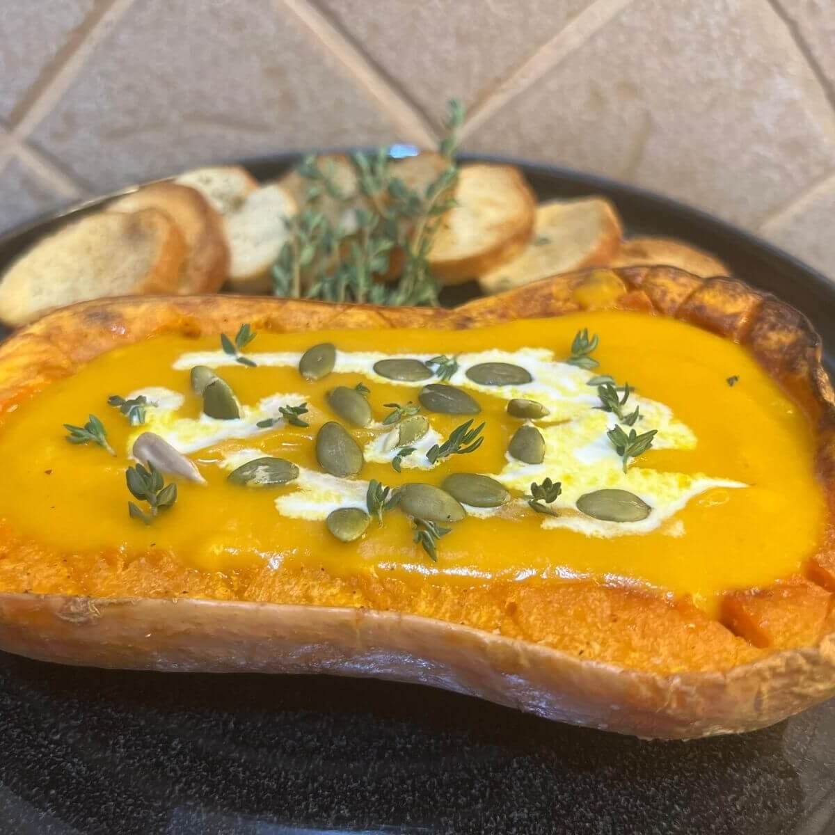 easy pumpkin soup recipe, the pumpkin is in a plate with the soup inside the pumpkin