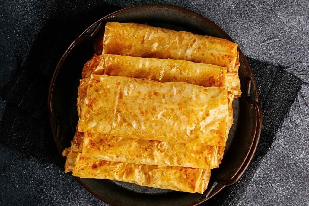 Golden crispy phyllo dough pastries baked until flaky and crunchy, demonstrating the perfect texture for a Baklava Cheese Pie.