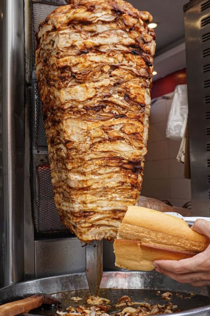 Traditional chicken shawarma cooking on a vertical rotisserie in a Lebanese restaurant