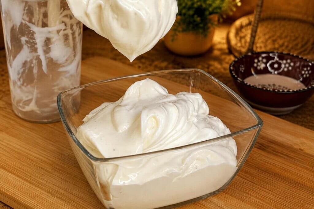 Creamy homemade mayonnaise with a thick, silky texture in a glass bowl