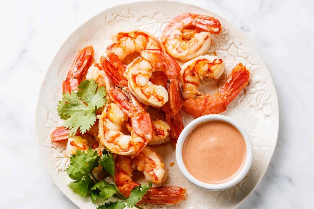 Grilled shrimp served with creamy homemade cocktail sauce and fresh coriander