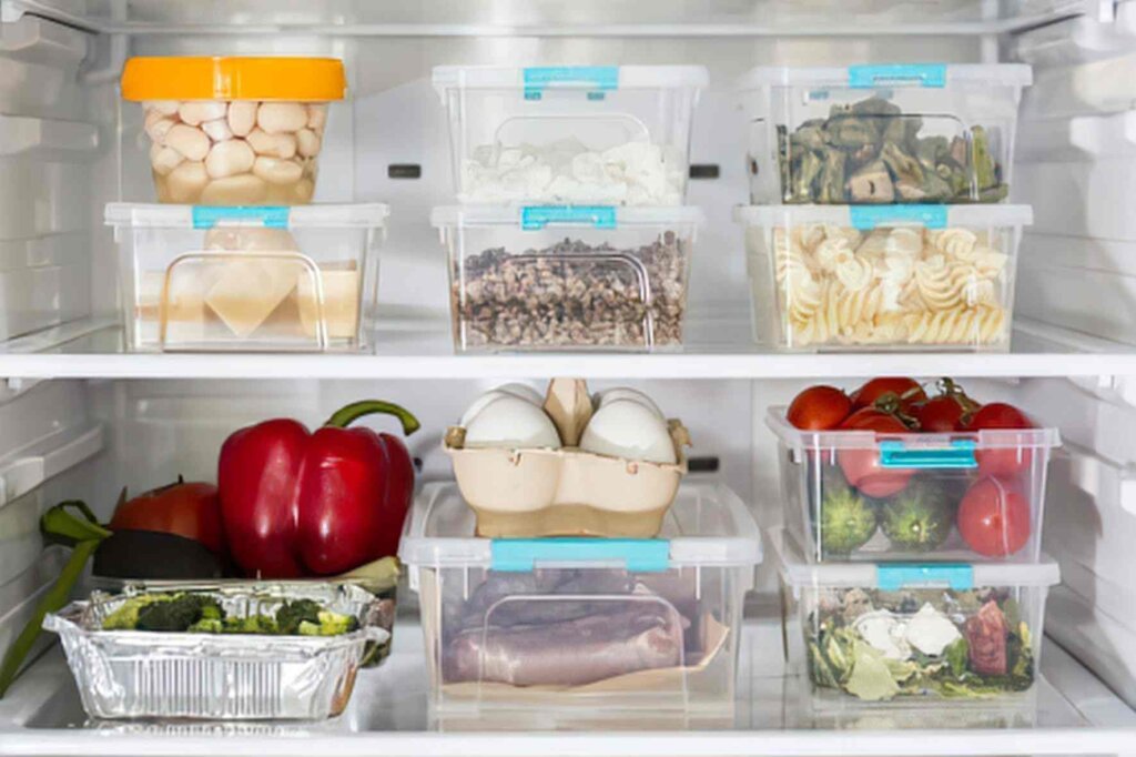 Refrigerator organization with labeled containers, vegetables, eggs, dairy products, and raw meat stored on separate shelves