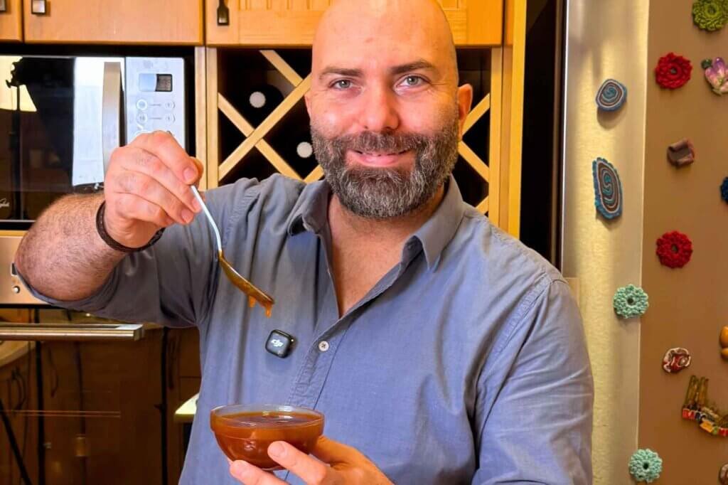 Chef François presenting a bowl of homemade sweet and sour dip in his kitchen